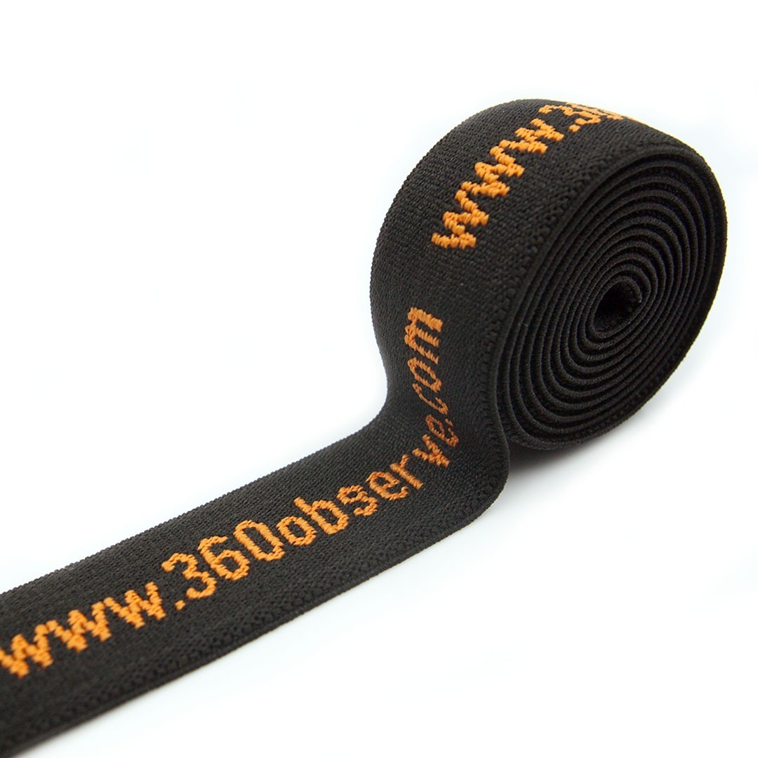 Guma tkana żakardowa w kolorze czarnym z pomarańczowym wzorem do produkcji szelek i wyrobów kaletniczych.
