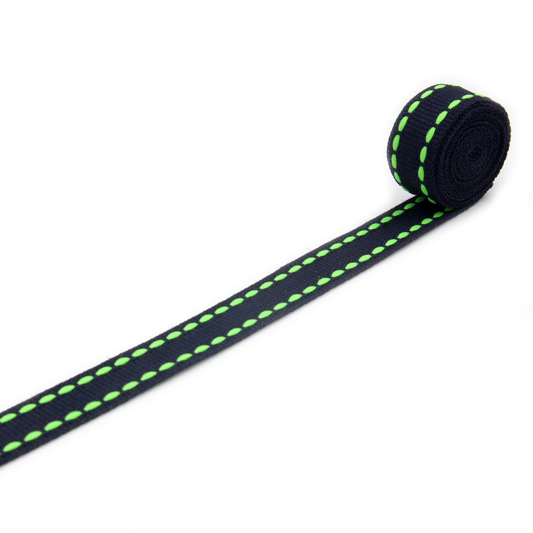 Lamówka tkana w kolorze czarnym z zielonymi przeszyciami przy krawędziach do odzieży i tkanin dekoracyjnych.